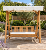 Teak garden swing bench with white canopy and matching seat cushion on a landscaped garden patio