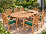 Oval teak extending garden dining table with eight matching high-back armchairs and green seat cushions
